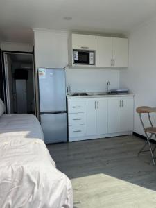 a kitchen with white cabinets and a refrigerator at Cabañas Vista Mar in Los Vilos