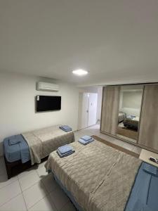 a hotel room with two beds and a mirror at Departamento Posadas Temporario Céntrico Alquiler in Posadas
