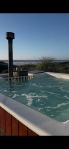 a hot tub with green water on a deck at PEZ HOUSE in Pichilemu