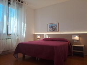 a bedroom with a bed with a purple blanket at B&B Locanda Al Pontesel in Garda