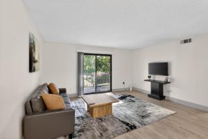 a living room with a couch and a tv at Contemporary 2BR apartment with workspace in Lenexa