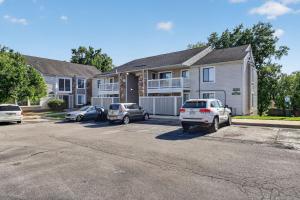 a house with two cars parked in a parking lot at Contemporary 2BR apartment with workspace in Lenexa