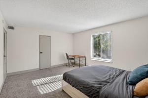 a bedroom with a bed and a table and a window at Contemporary 2BR apartment with workspace in Lenexa