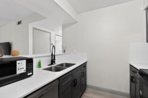 a kitchen with a sink and a microwave at Contemporary 2BR apartment with workspace in Lenexa +7 photos