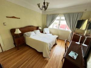 a bedroom with a bed and a television in it at Alma Roma, Hogar con Alma, B&B in Mexico City +20 photos