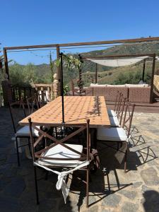 a wooden table and chairs on a patio at Finca RustiQ in Torrox +11 photos