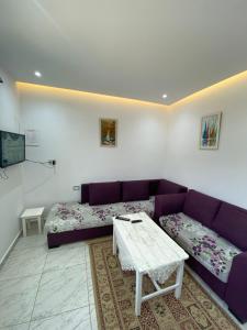 a living room with a purple couch and a table at Mina résidence A0 in Kelibia