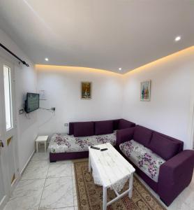 a living room with a purple couch and a table at Mina résidence A0 in Kelibia