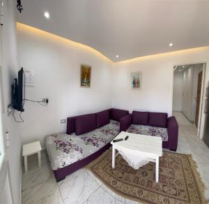 a living room with a purple couch and a table at Mina résidence A0 in Kelibia +18 photos