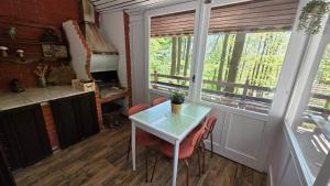 a small kitchen with a table and chairs and windows at Forest House Bukulja in Arandelovac +28 photos