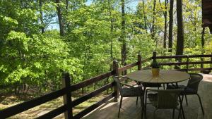 a table and chairs on the porch of a cabin at Forest House Bukulja in Arandelovac