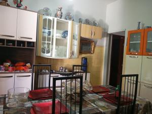 a kitchen with white cabinets and a table with chairs at Férias pé na areia, sol e mar in Serra +1 photo