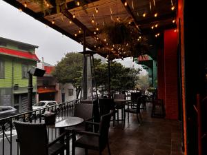 an outdoor patio with tables and chairs and lights at Taormina Hotel y Casino in San José