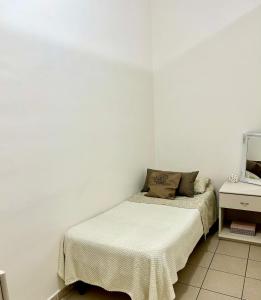 a white bedroom with a bed and a mirror at diamond room in Palmi +2 photos