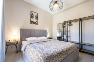 a bedroom with a large bed and a chandelier at Crystal Private Pool House in Artemida