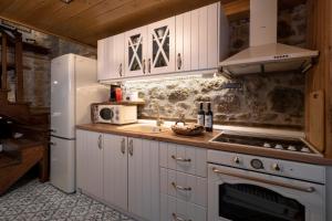 a kitchen with white cabinets and a white refrigerator at Martinis House in Pefkochori