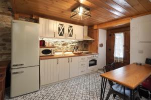 a kitchen with white appliances and a wooden ceiling at Martinis House in Pefkochori