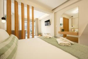 a bedroom with a bed with two towels on it at MarAzul Luxury Suites in Flogita