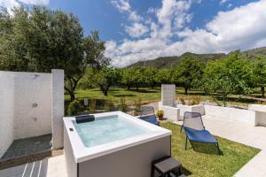 a hot tub in a yard with chairs and trees at Villa Gisa - Oasi Mediterranea in Calalunga-Pietragrande