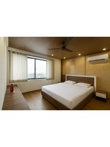 a bedroom with a white bed and a large window at Hotel Walk Inn in Faridabad +32 photos