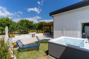 a hot tub in a yard with two chairs at Villa Gisa - Oasi Mediterranea in Calalunga-Pietragrande +105 photos