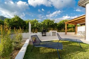 a patio with two chairs and a grill at Villa Gisa - Oasi Mediterranea in Calalunga-Pietragrande