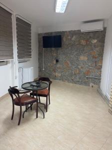 a room with a table and chairs and a stone wall at CHRIS SOPO in Ohrid