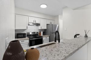 a kitchen with white cabinets and a granite counter top at Spacious 2BR stay with updated interiors in Lenexa +7 photos