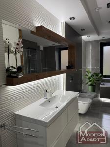 a bathroom with a white sink and a toilet at Modern Apart in Wałbrzych +23 photos
