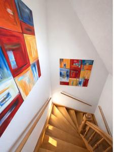 a staircase with two paintings on the wall at FeWo Findling Ruegen in Putbus