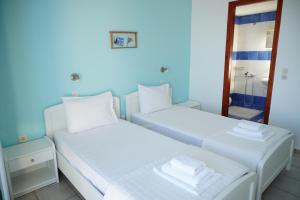 two beds in a room with a mirror at Gigilos in Agia Roumeli +37 photos