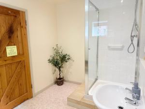 a bathroom with a sink and a shower with a glass door at Pandy Barn Berriew in Welshpool +22 photos