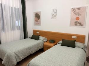 a bedroom with two beds and a window at Casa Tío Tato , cerca de Puy du Fou y Toledo in Polán +39 photos