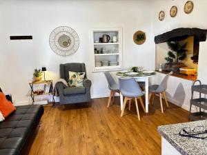 a living room with a couch and a table and chairs at Casa Jardim 21 in Prazeres