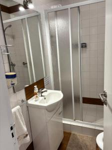 a white bathroom with a shower and a sink at Casa Jardim 21 in Prazeres