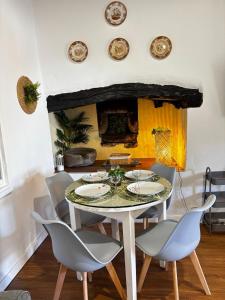 a dining room with a table and chairs and a fireplace at Casa Jardim 21 in Prazeres +17 photos