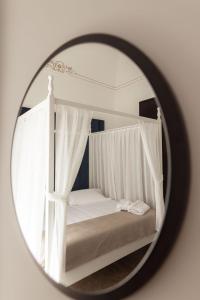 a mirror reflection of a bed with white canopy at Villa Del Lauro in Ragusa
