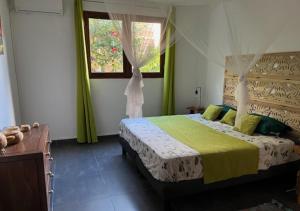 a bedroom with a bed and a window at Gite La Tortue Bleue piscine & Malendure in Bouillante +18 photos
