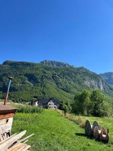 a house in a field with mountains in the background at Nana Time Guesthouse in Vusanje +27 photos