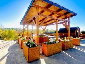 Ein Holzpavillon mit Topfpflanzen auf einer Terrasse in der Unterkunft Gackowo - teren rekreacyjny nad jeziorem in Ostróda