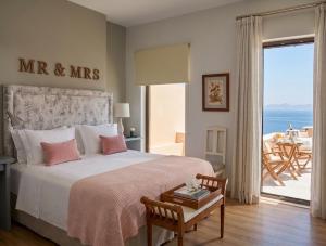 a bedroom with a bed with a view of the ocean at Arion Syros Luxury Rooms and Suites in Ermoupoli