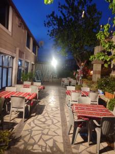 a group of tables and chairs on a patio at night at Anatolia Hotel in Pamukkale