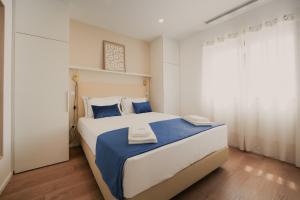 a bedroom with a large bed with blue and white sheets at Villa d'Avó Dalva in Vila Chã