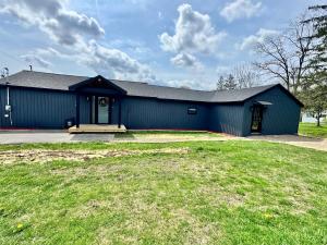 a blue building with a grass yard in front of it at Arminta Street Retreat in DuBois