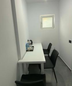 a white table and two chairs in a room at Paolo's Apartments in Shëngjin +5 photos