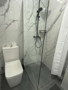 a white bathroom with a shower and a toilet at Paolo's Apartments in Shëngjin