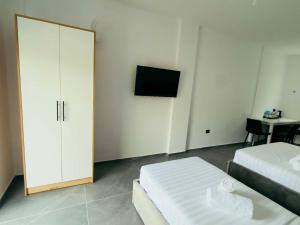 a bedroom with two beds and a tv in it at Paolo's Apartments in Shëngjin