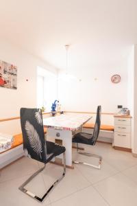 a dining room with a table and two chairs at Casa vacanze Maria in Tesero
