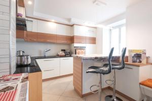 a kitchen with a counter and two black stools at Casa vacanze Maria in Tesero
