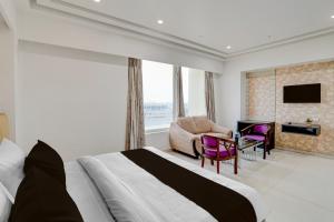 a bedroom with a bed and a chair and a desk at Palette A Lux Corporate Townhouse Near 3 Minutes Kaushambi Metro Station in Ghaziabad +110 photos